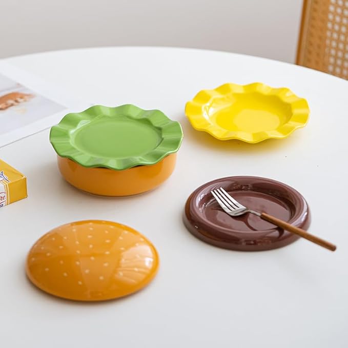 The Ceramic Hamburger Plates Collection is a creative 5-piece set of hamburger-shaped plates and bowls made of durable and elegant ceramic for a unique dining experience and fun.